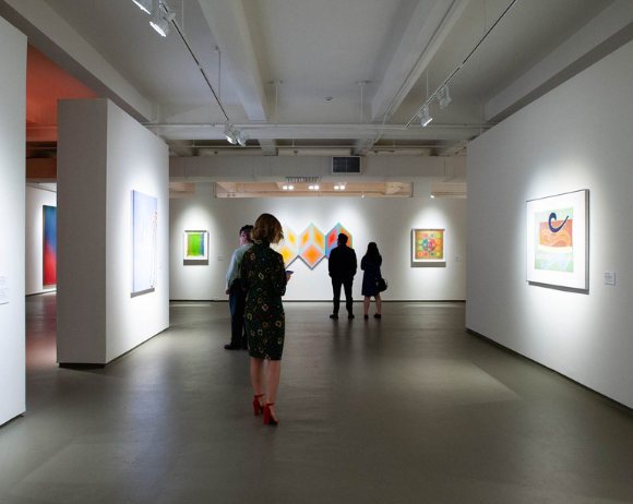 people walking around a gallery exhibit