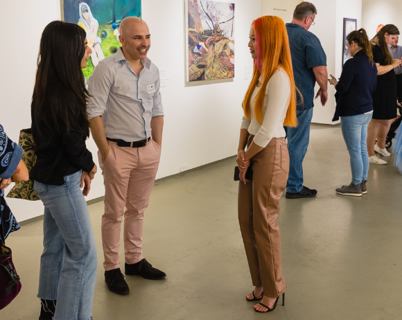 a group of people chatting in the gallery