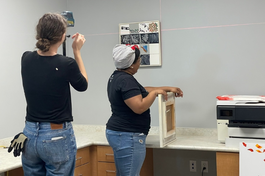 MOCA curatorial team installing artwork at GOCA Charter School