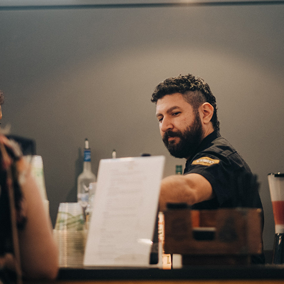 Bartender at MOCA Bar preparing a drink.