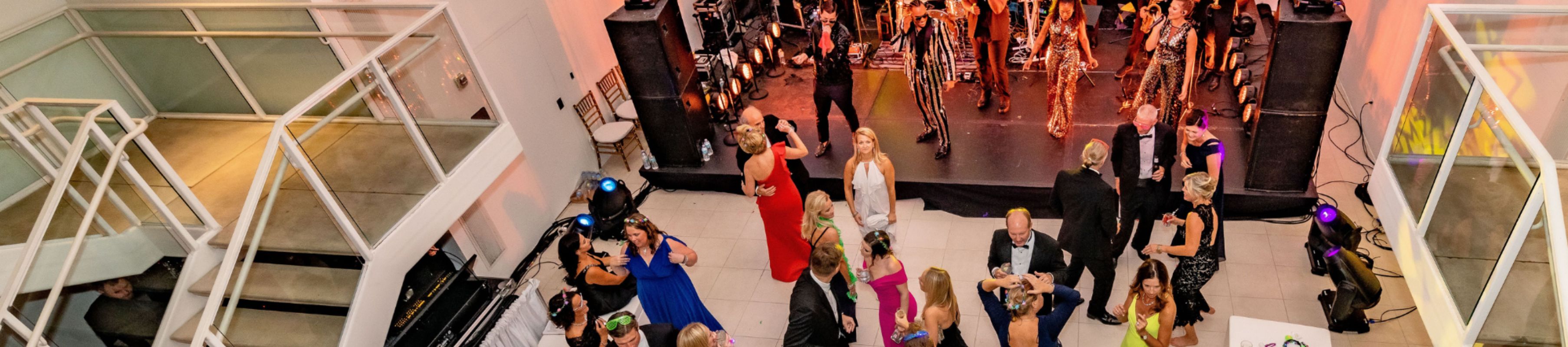 a group of people dancing in MOCA's Atrium Gallery as a live band plays